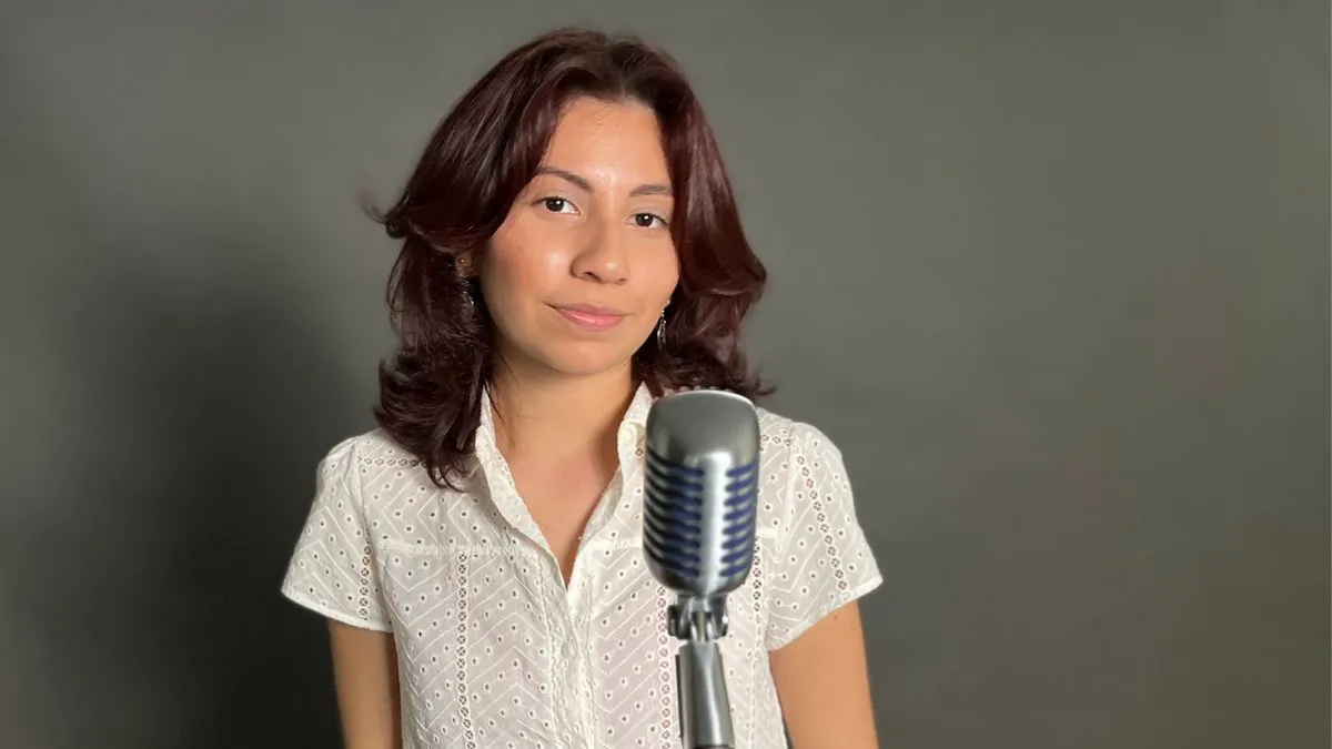 Indie Maryland-based artist Mia Celeste poses in front of microphone smiling slightly.